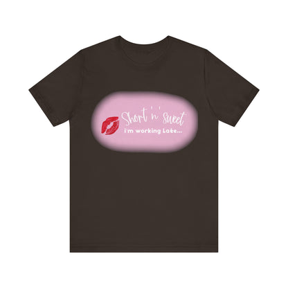 Sabrina Carpenter Inspired Unisex Short Sleeve Tee with Vibrant Lipstick Print in classic black, showcasing the fun phrase 'Short n' sweet i'm working Late...' along with an eye-catching red lipstick mark.