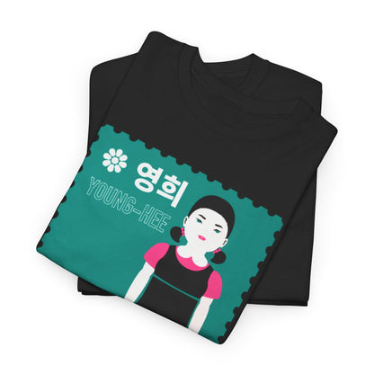 Elegantly folded black cotton t-shirt featuring a playful graphic of Young-Hee from Squid Game, showcasing vibrant teal and pink details for a stylish, unisex look.