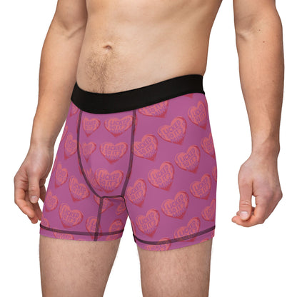Model wearing Valentine's Naughty Cheeky Men's Boxer Briefs in a seductive stance, emphasising the bold heart graphic and playful text for a romantic statement.