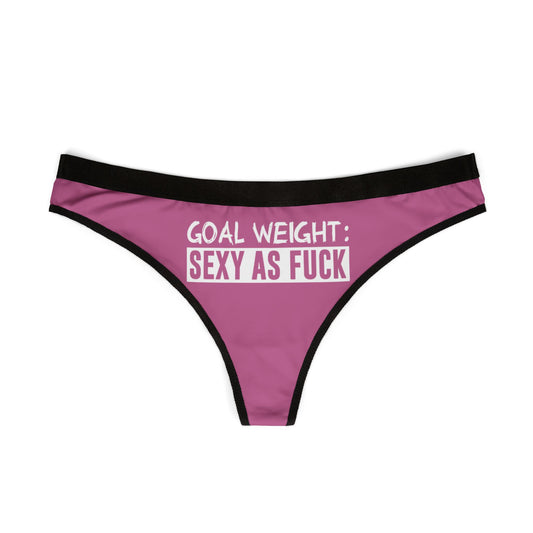 Chic pink thong with a black trim, prominently displaying the empowering phrase 'GOAL WEIGHT: SEXY AS F*CK', perfect for adding a cheeky touch to intimate apparel collections.