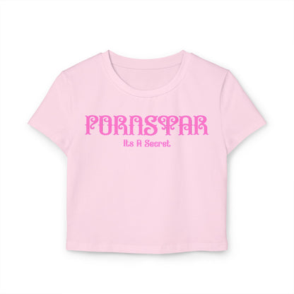 Cheeky women's cropped t-shirt in soft pink with stylish 'Pornstar' graphic and the phrase 'It's A Secret', crafted from 100% organic cotton for a sustainable fashion statement.