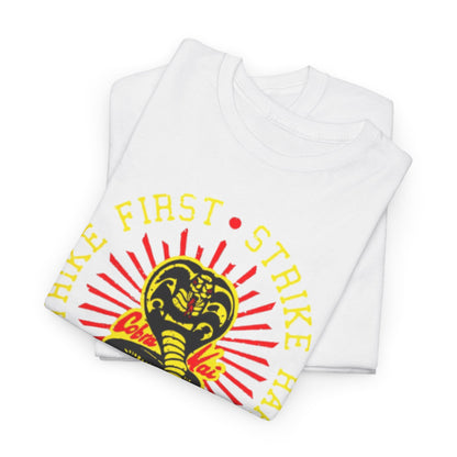 Sumptuous folded white t-shirts revealing the iconic Cobra Kai design, depicting a fierce snake and motivational text 'Strike First, Strike Hard, No Mercy', a stylish choice for any wardrobe.