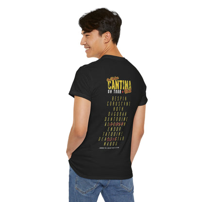 Back view of a man in the Star Wars Cantina Band Tour T Shirt featuring a vintage-inspired list of galactic destinations, such as 'BESPIN' and 'CORUSCANT', embodying a luxurious tribute to sci-fi culture.