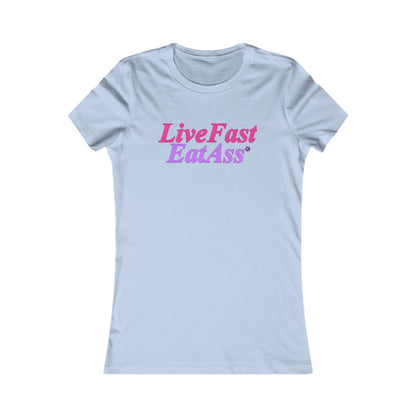 Sophisticated women's fitted t-shirt in light blue adorned with the fun phrase 'Live Fast Eat Ass®' presented in a colorful blend of pinkish-purple and hot pink, ideal for a playful yet refined look.