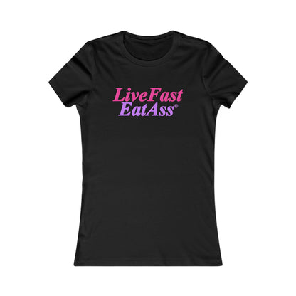 Luxurious black fitted women's t-shirt showcasing the striking phrase 'Live Fast, Eat Ass®' in a stylish pink and purple gradient, ideal for trendy, bold fashion.