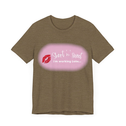 Sabrina Carpenter Inspired Unisex Short Sleeve Tee in a sophisticated brown tone, adorned with a vibrant lipstick print stating 'Short 'n' Sweet, I'm Working Late...'.