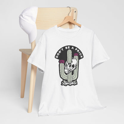 Sophisticated white t-shirt displayed alongside a minimalist wooden chair, featuring the striking ‘DON'T BE A PRICK’ cactus and skull graphic, ideal for casual yet stylish wear.