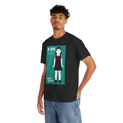 Stylish young man presenting a black t-shirt with a striking Young-Hee illustration from Squid Game, exuding contemporary elegance and casual flair.