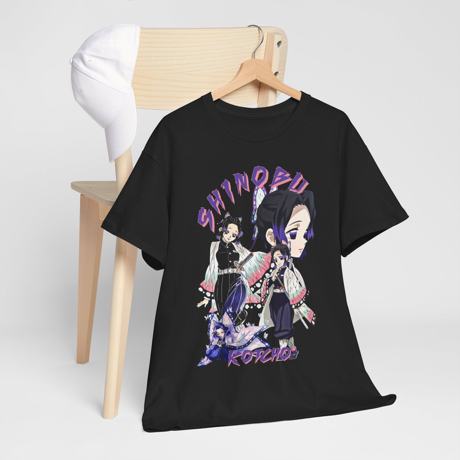 Elegant black anime T-shirt displayed on a wooden chair, showcasing detailed artwork of Shinobu Kocho from Demon Slayer, paired with a stylish cap for a chic look.