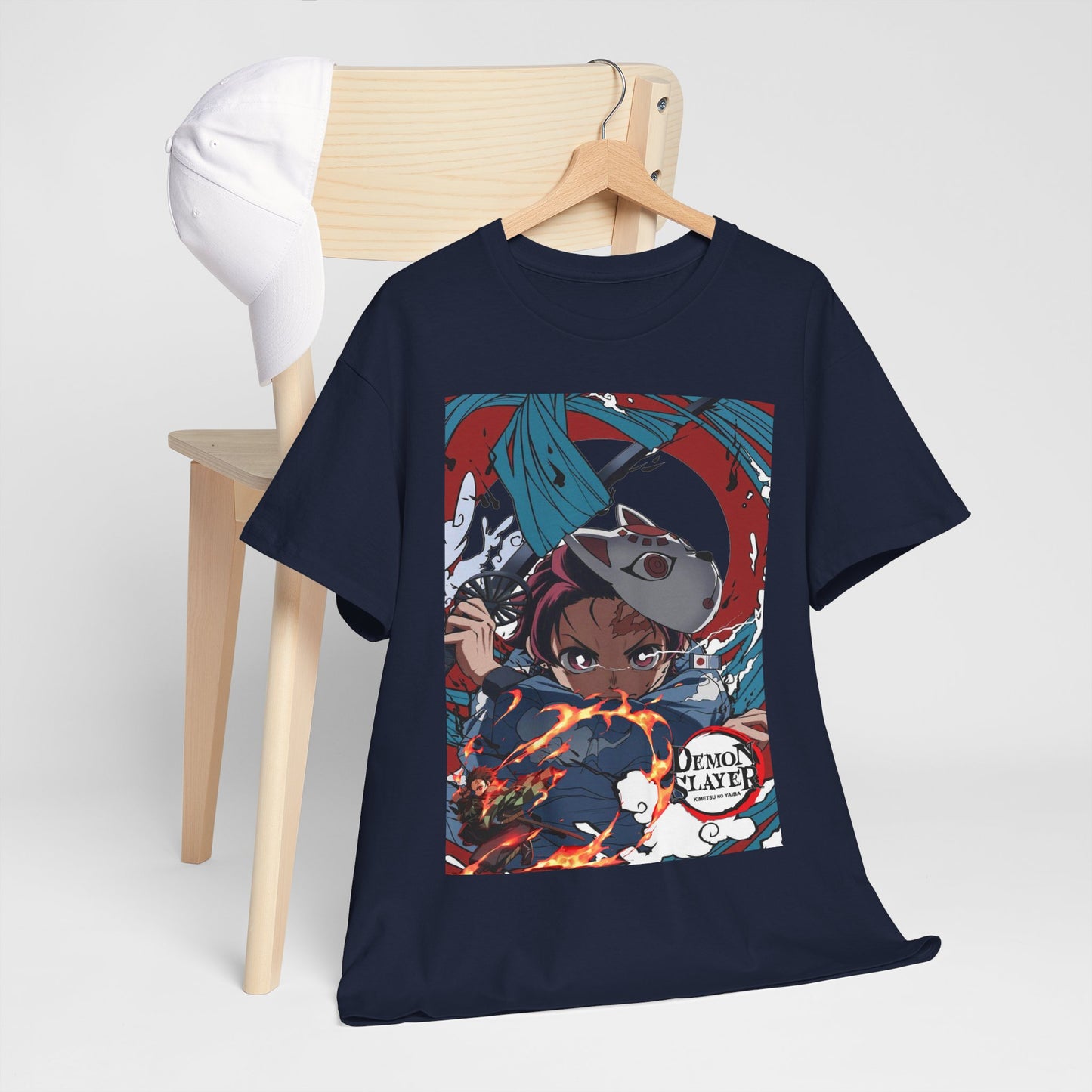 Sophisticated navy t-shirt displayed over a wooden chair, featuring a striking illustration of Tanjiro Kamado from Demon Slayer, complemented by a classic white cap, perfect for modern anime fans.