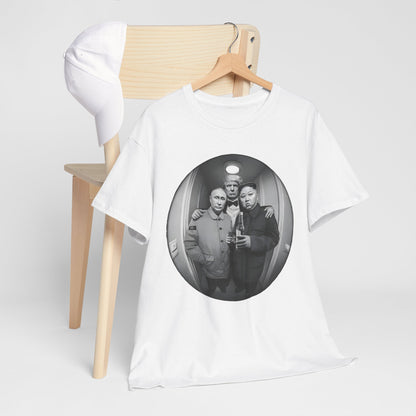 Luxurious white graphic t-shirt featuring a humorous illustration of political leaders in a fisheye lens view, displayed on a stylish wooden hanger beside a cap.