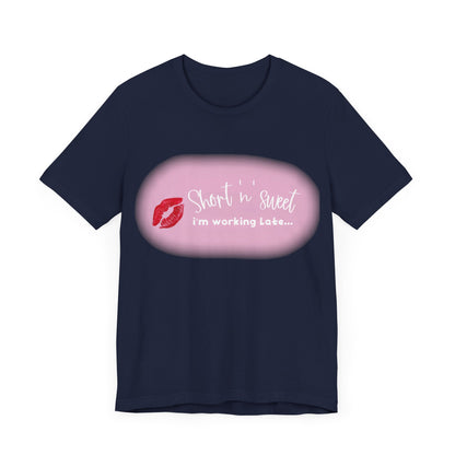 Sabrina Carpenter Inspired Unisex Short Sleeve Tee featuring a vibrant lipstick print with the phrase 'Short 'n' sweet, I'm working late...' on a dark navy background, ideal for fashion-forward individuals.
