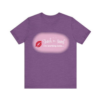Sabrina Carpenter Inspired Unisex Short Sleeve Tee in a rich purple hue, featuring a vibrant lipstick print with the phrase 'Short 'n sweet i'm working Late...', a statement of individuality.