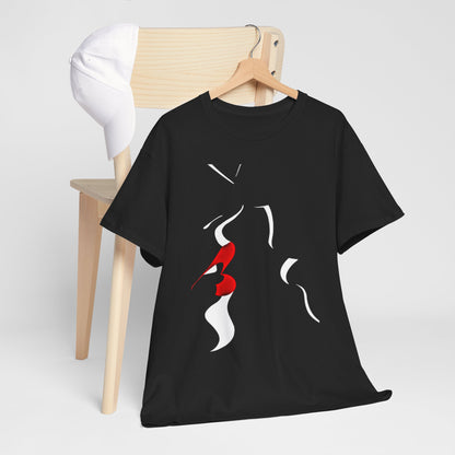 Chic black graphic t-shirt displayed on a wooden chair next to a white cap, featuring a captivating design of abstract faces and a bold red kiss for a stylish look.