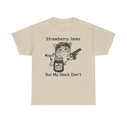 Luxurious beige graphic t-shirt featuring a playful cat holding a jar of strawberry jam and a handgun with the text 'Strawberry Jams But My Glock Don't.' Perfect for those who embrace unique style.