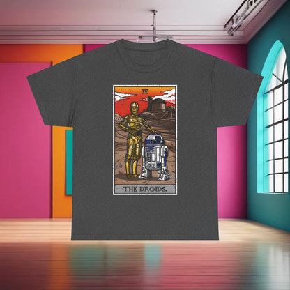The Droids Tarot Card Graphic T-Shirt Urban Unisex Cotton Tee displayed in a stylish setting with a grey fabric background, featuring C-3PO and R2-D2 illustrations against a vibrant orange-red sunrise.