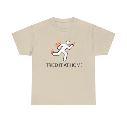 Elegant beige mens t-shirt showcasing a dynamic stick figure in motion surrounded by vibrant flames, emphasising the bold statement 'I TRIED IT AT HOME' for an inspiring touch.