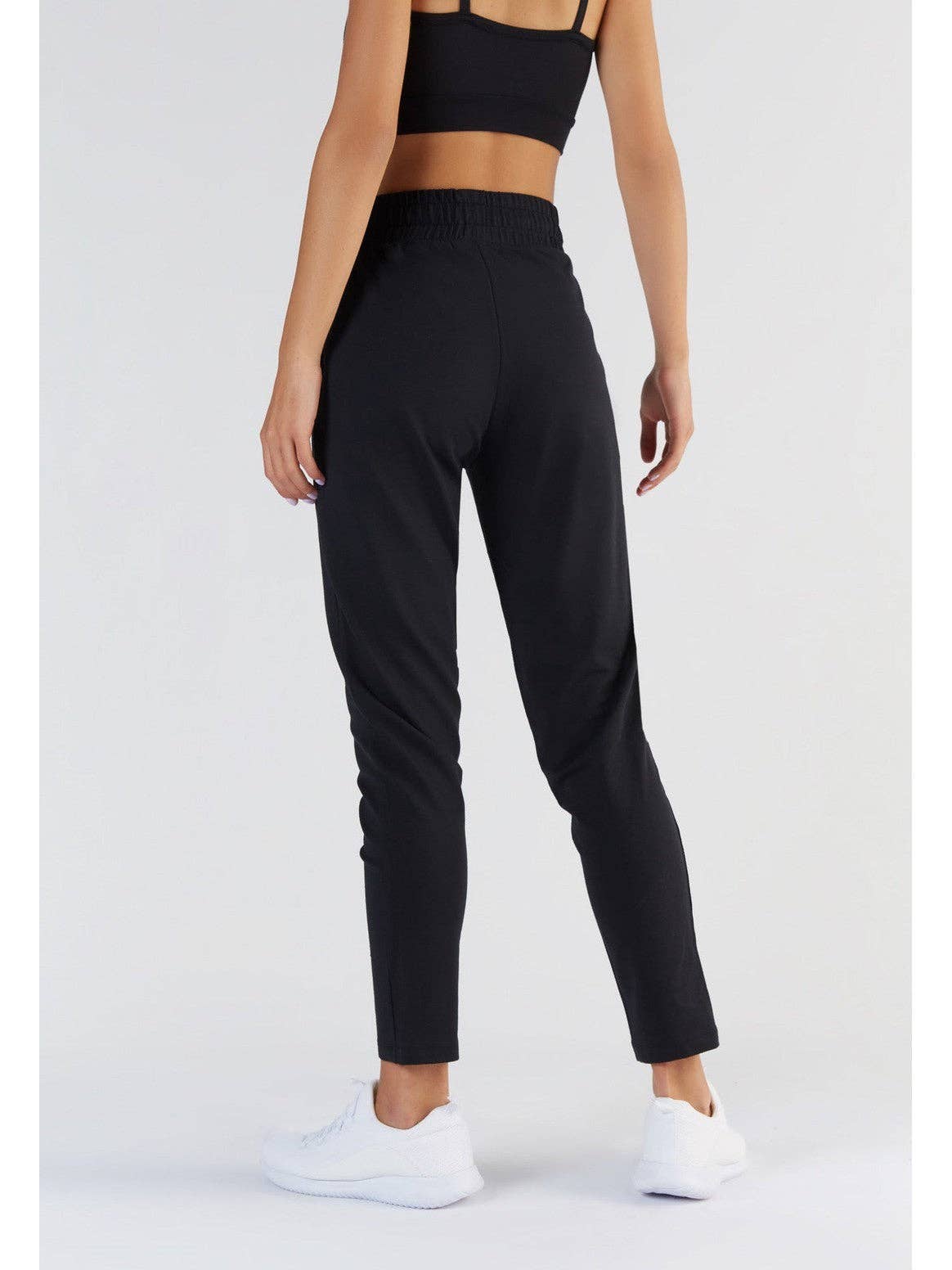Adjustable elastic waistband with a draw-cord detail on women's sweatpants, emphasizing versatile fit and style.
