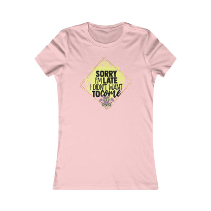 Chic women's pink t-shirt showcasing a stylish graphic design stating 'Sorry I'm Late, I Didn't Want to Come,' elegantly outlined in a diamond shape, embellished with yellow hues and floral details.