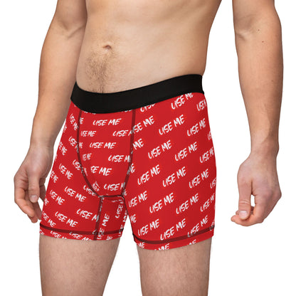 Stylish model wearing luxurious red men's boxer briefs with cheeky 'USE ME' text, symbolising comfort and flirtation in intimate apparel.