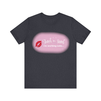 Sabrina Carpenter Inspired Unisex Short Sleeve Tee featuring a vibrant lipstick print, showcasing the phrase 'Short 'n sweet i'm working Late...' on a dark background, embodying style and flair.