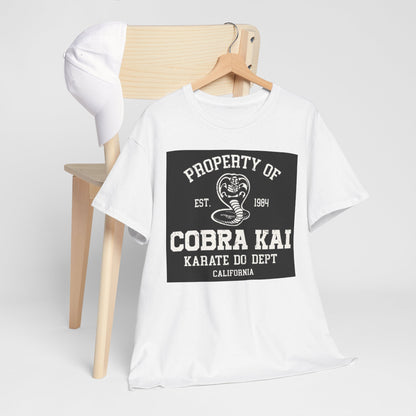 Luxury white t-shirt with the iconic Cobra Kai logo draped over a chair, set against a minimalist background, ideal for martial arts aficionados.