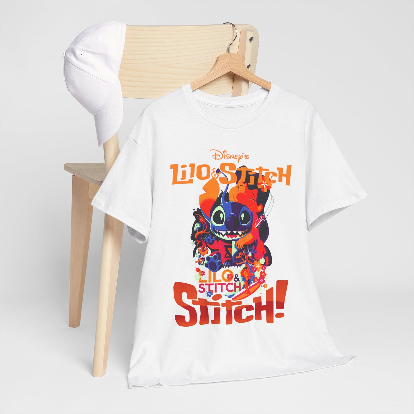 Trendy Lilo & Stitch graphic t-shirt displayed stylishly on a wooden hanger next to a baseball cap, showcasing vibrant colours and playful design for Disney fans.