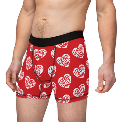 A model showcasing Valentine's Naughty Cheeky Men's Boxer Briefs, designed with a humorous heart print and the playful text 'I LICKED IT SO IT'S MINE', perfect for celebrating love on special occasions.