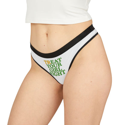 Elegant woman showcasing a stylish white thong with bold 'TREAT YOUR GIRL RIGHT' design in vibrant yellow and green typography, complemented by refined black trim.