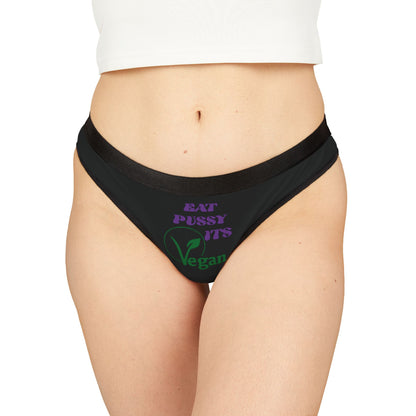 Elegant women's thong panties featuring a playful design with the phrase 'EAT PUSSY, IT’S VEGAN' printed in vibrant purple and green colours, showcasing a cheeky style perfect for modern and eco-conscious fashion.