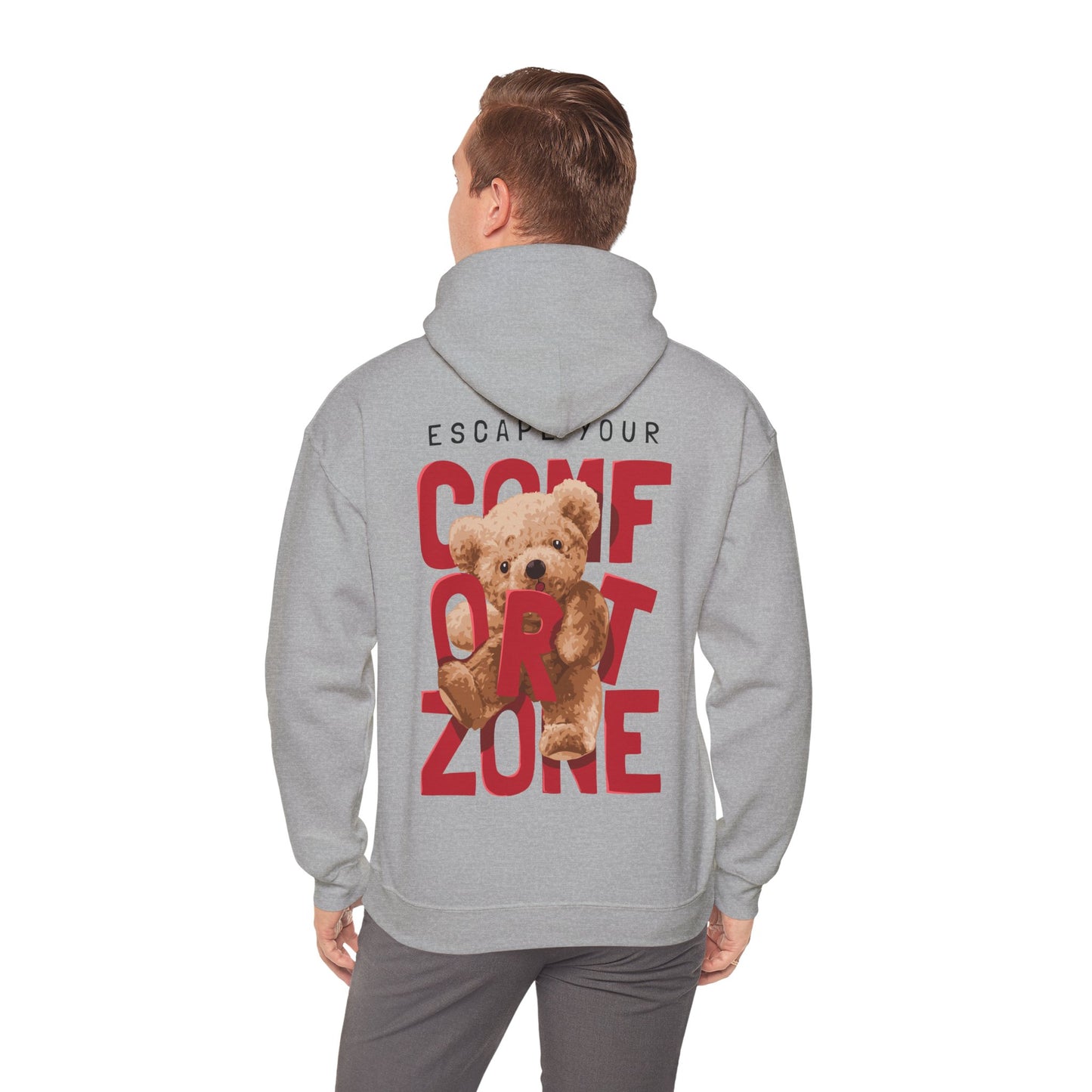 Model wearing a luxury grey hoodie with a bold back print reading 'ESCAPE YOUR COMFORT ZONE', featuring a playful teddy bear graphic, exemplifying contemporary fashion and comfort.