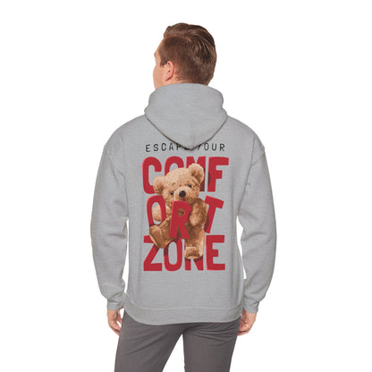 Model wearing a luxury grey hoodie with a bold back print reading 'ESCAPE YOUR COMFORT ZONE', featuring a playful teddy bear graphic, exemplifying contemporary fashion and comfort.