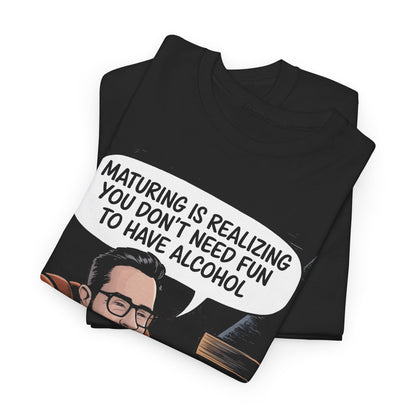 Elegant Maturing with Alcohol Graphic T-Shirt featuring a playful caricature of a gentleman in an armchair, holding a drink, embellished with the witty phrase, 'MATURING IS REALIZING YOU DON'T NEED FUN TO HAVE ALCOHOL', crafted from soft cotton for ultimate comfort.