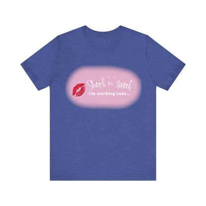 Sabrina Carpenter Inspired Unisex Short Sleeve Tee with Vibrant Lipstick Print in a heathered blue tone showcasing the saying 'Short n sweet, I'm working Late...' alongside a glamorous lipstick print.