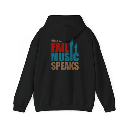 Stylish black hoodie displaying the motivational phrase 'When Words Fail Music Speaks' in captivating colours, accented by guitar graphics, perfect for a bold fashion statement.