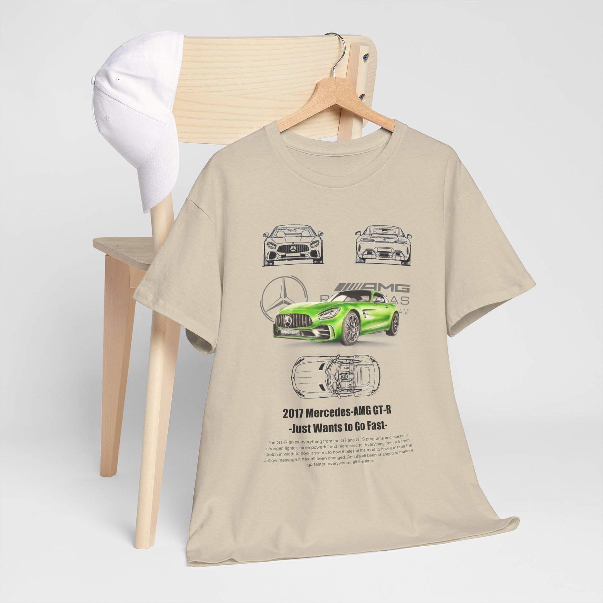 Sophisticated men's t-shirt displayed with a green Mercedes-AMG GT-R graphic, elegantly positioned near a minimalist chair, epitomizing luxury automotive fashion.