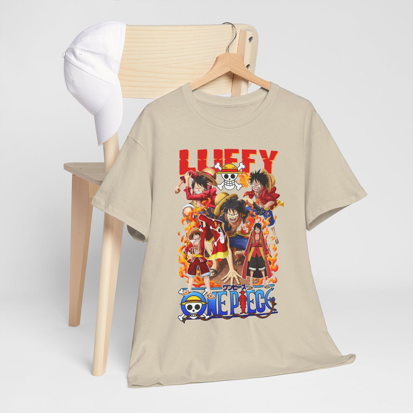 Artistic presentation of a beige t-shirt with striking One Piece anime graphics, elegantly hanging alongside a white baseball cap, perfect for a versatile and fashionable look.