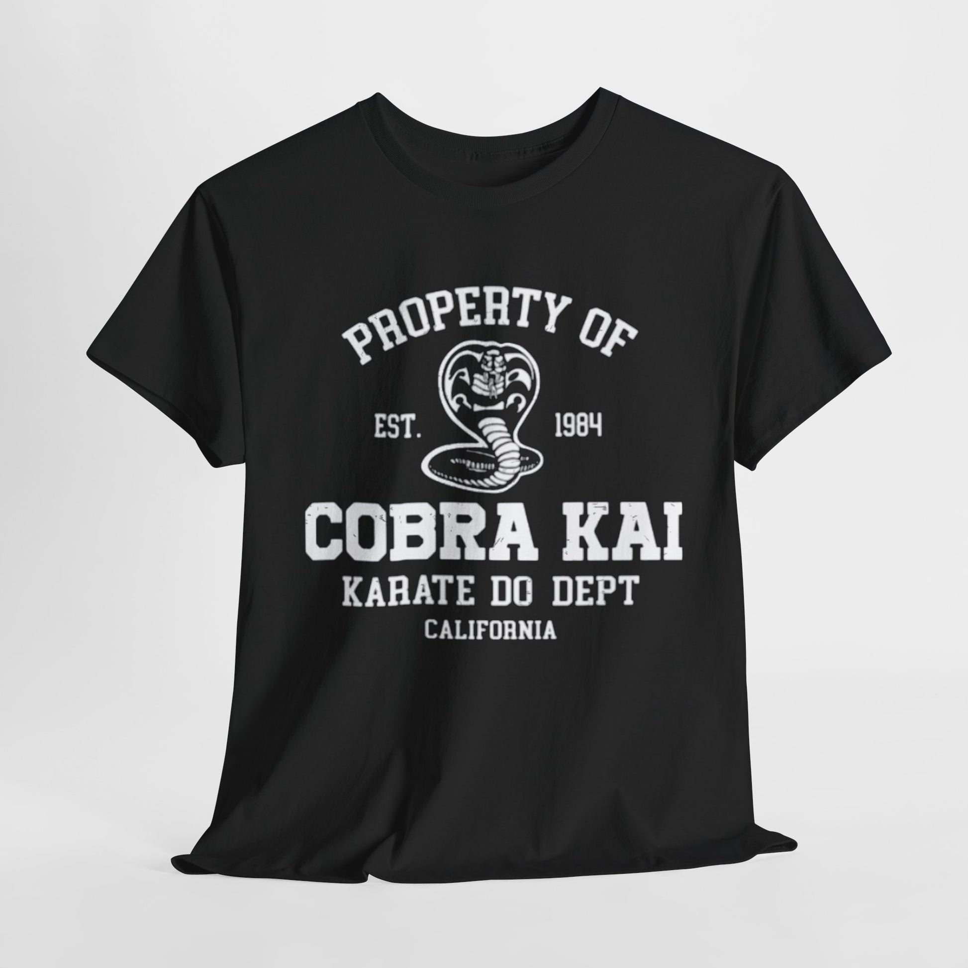 Luxurious black graphic T-shirt featuring the iconic Cobra Kai logo, with bold white text reading 'Property of Cobra Kai Karate Do Dept California', est. 1984, embodying a stylish homage to martial arts nostalgia.
