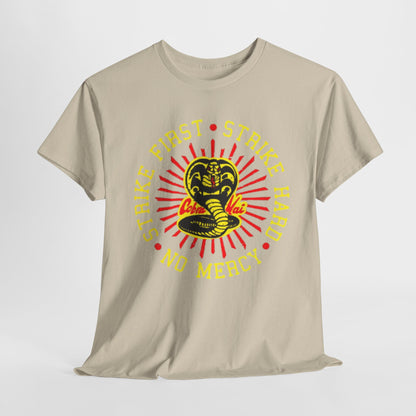 Elegant graphic T-shirt featuring a striking Cobra Kai design with the phrase 'Strike First, Strike Hard, No Mercy'. Perfect for fans of martial arts and vintage pop culture, showcasing a bold snake emblem surrounded by vibrant rays.