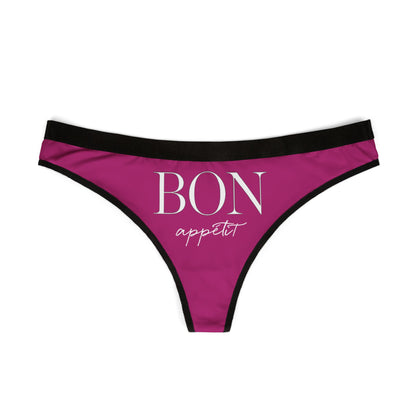 Chic and seductive women's thong in vibrant purple, showcasing the whimsical text 'BON appétit' in sophisticated typography, complemented by sleek black edging, perfect for adding humour and flair to lingerie collections.