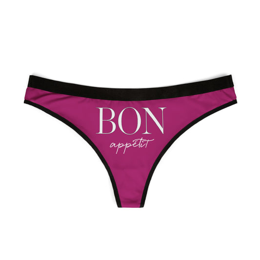 Chic and seductive women's thong in vibrant purple, showcasing the whimsical text 'BON appétit' in sophisticated typography, complemented by sleek black edging, perfect for adding humour and flair to lingerie collections.