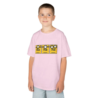 A smiling boy in a pink Minions Kids T-Shirt showcasing a unique periodic table design with Barium and Sodium. This playful and educational tee is ideal for kids who love both science and the Minions, making learning fun. T Shirt, Funny, Minions.