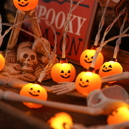 Charming PVC Soft Material Halloween Lighting Chain showcasing smiling pumpkin lights intertwined with a decorative skeleton, ideal for creating a spooky yet inviting ambiance for Halloween celebrations.