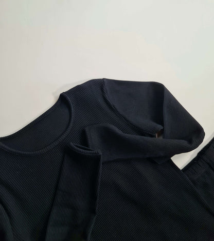 Elegant black matching family pyjamas designed by DreamBuy, featuring soft ribbed fabric suitable for all ages from 3 months to XXL, perfect for stylish comfort during family gatherings.