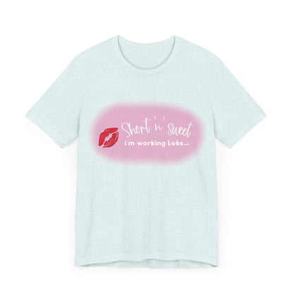 Front view of the Sabrina Carpenter Inspired Unisex Short Sleeve Tee showcasing a vibrant lipstick print with the text 'Short 'n' sweet, I'm working late...' designed for stylish fans.