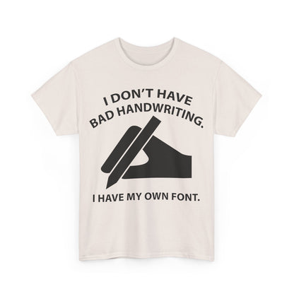 Stylish unisex t-shirt featuring the humorous phrase 'I DON'T HAVE BAD HANDWRITING. I HAVE MY OWN FONT.' with an artistic hand graphic, perfect for a chic and creative wardrobe.