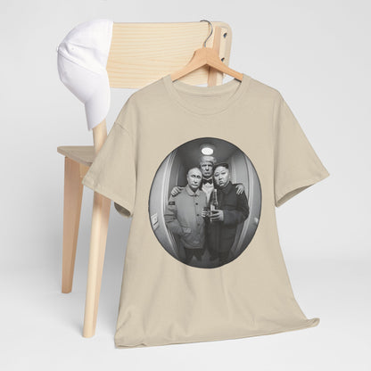 Elegant beige graphic t-shirt featuring a playful design of three world leaders in a fisheye lens perspective, styled nonchalantly in an elevator. A sophisticated addition to any wardrobe, perfect for sparking conversation.