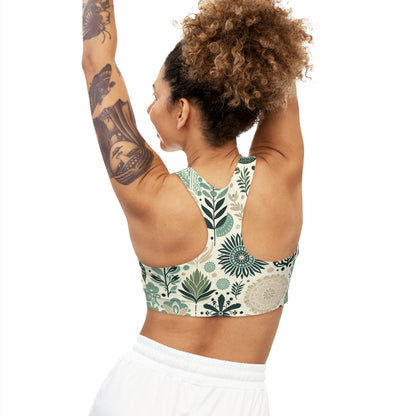 Leilani Beaumont Pastel Green Sports Bra showcasing a modern design with organic shapes, featuring a model with curly hair and tattoos, raising her arms enthusiastically. This luxury activewear piece exemplifies ultimate support and stylish aesthetics for fitness enthusiasts.