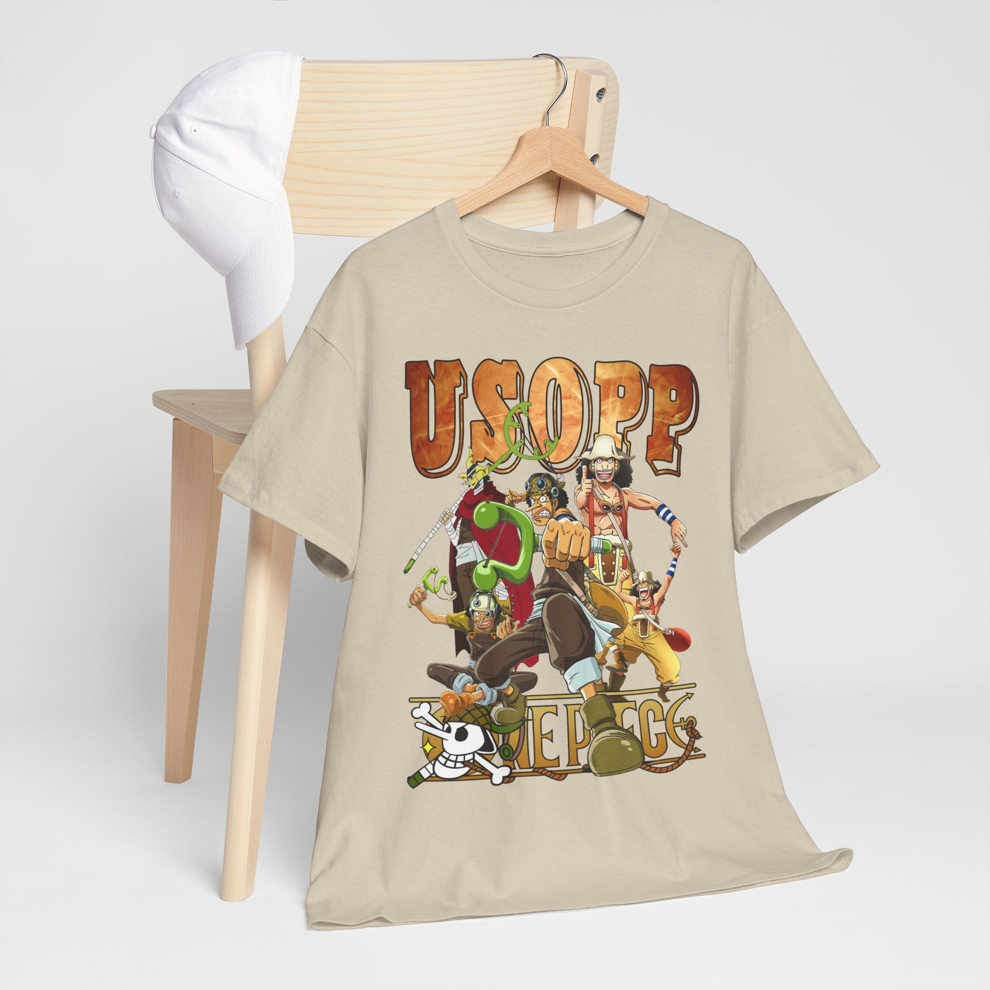 Stylish Usopp T-shirt arranged on a wooden chair, coupled with a fashionable cap, highlighting iconic anime characters in a bright design.