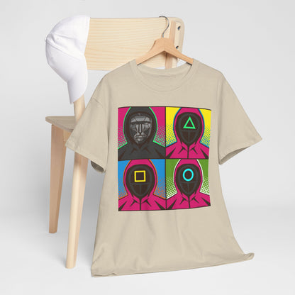 Squid Game Pop Art Unisex T-Shirt displayed on a chair beside a cap, showcasing a colourful graphic of masked figures in a striking comic-style grid.